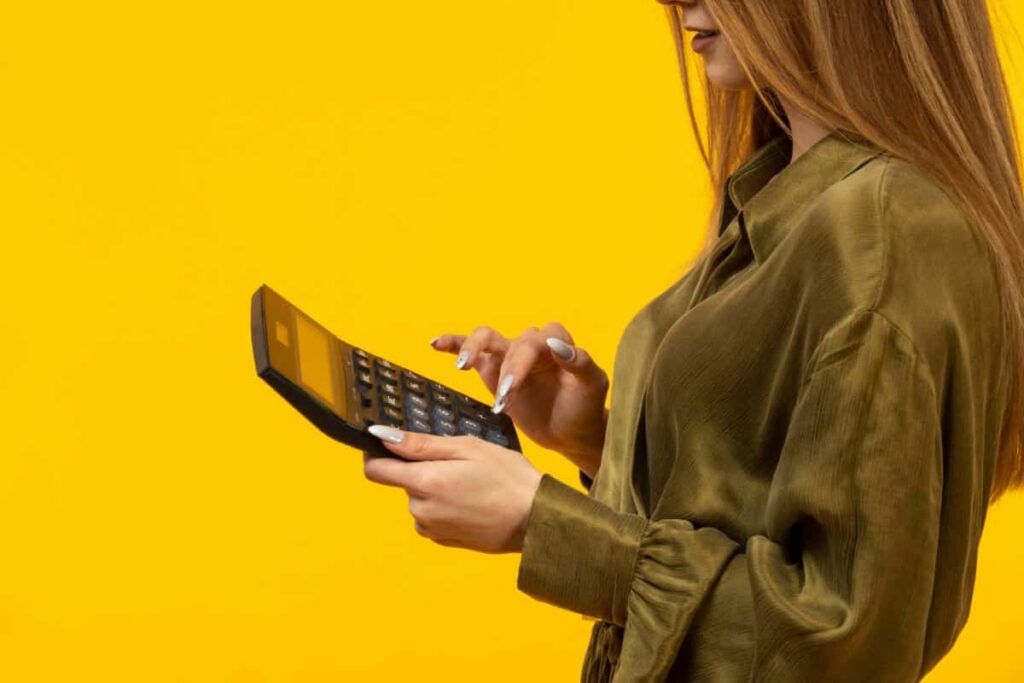 woman-green-pullover-uses-calculator
