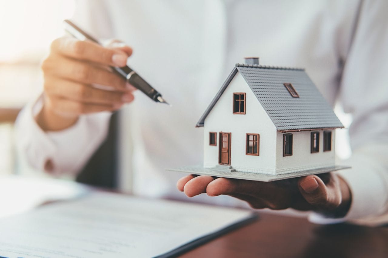house model with real estate agent customer discussing contract buy house